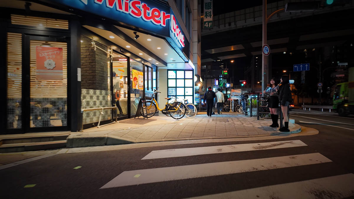 Girls bar staff standing in front of Mister Donut near the north exit of Fukushima Station on the JR Osaka Loop Line