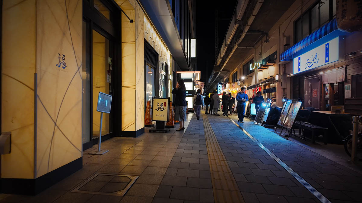 Bars and izakayas lining the south side of Fukushima Station, with drinkers spilling out