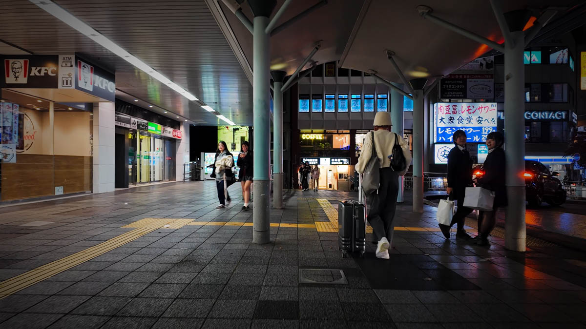 High school girls in Halloween costumes gathered in front of JR Wakayama Station at night