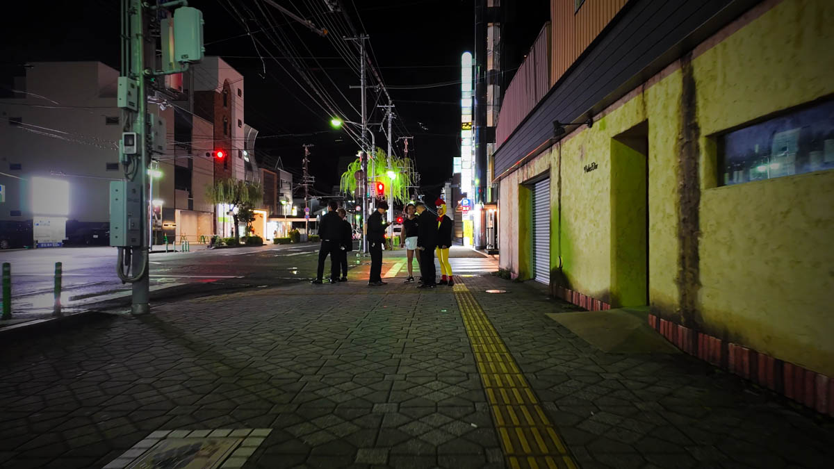 Yanagi-dori entertainment district at night, touts standing outside bars
