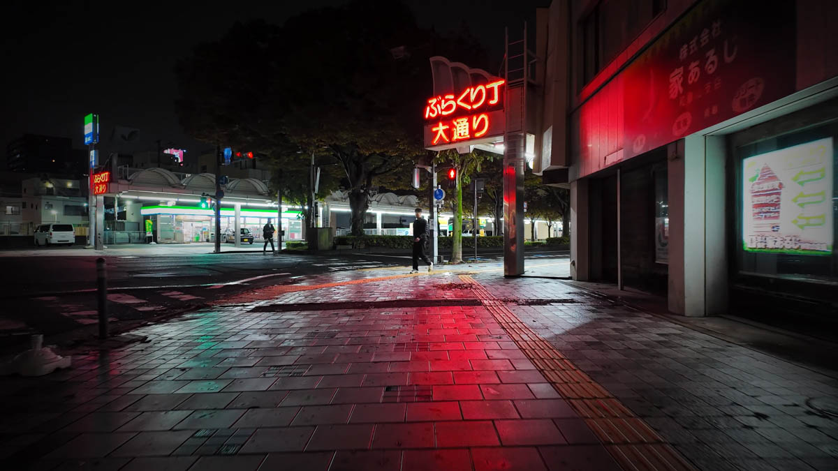 A neon-lit corner of the arcade, where only the footpath is covered