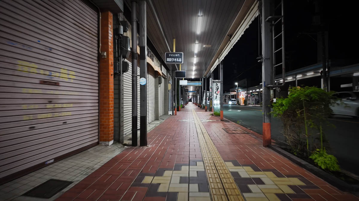 An arcade shopping street further from the station, many shops closed up