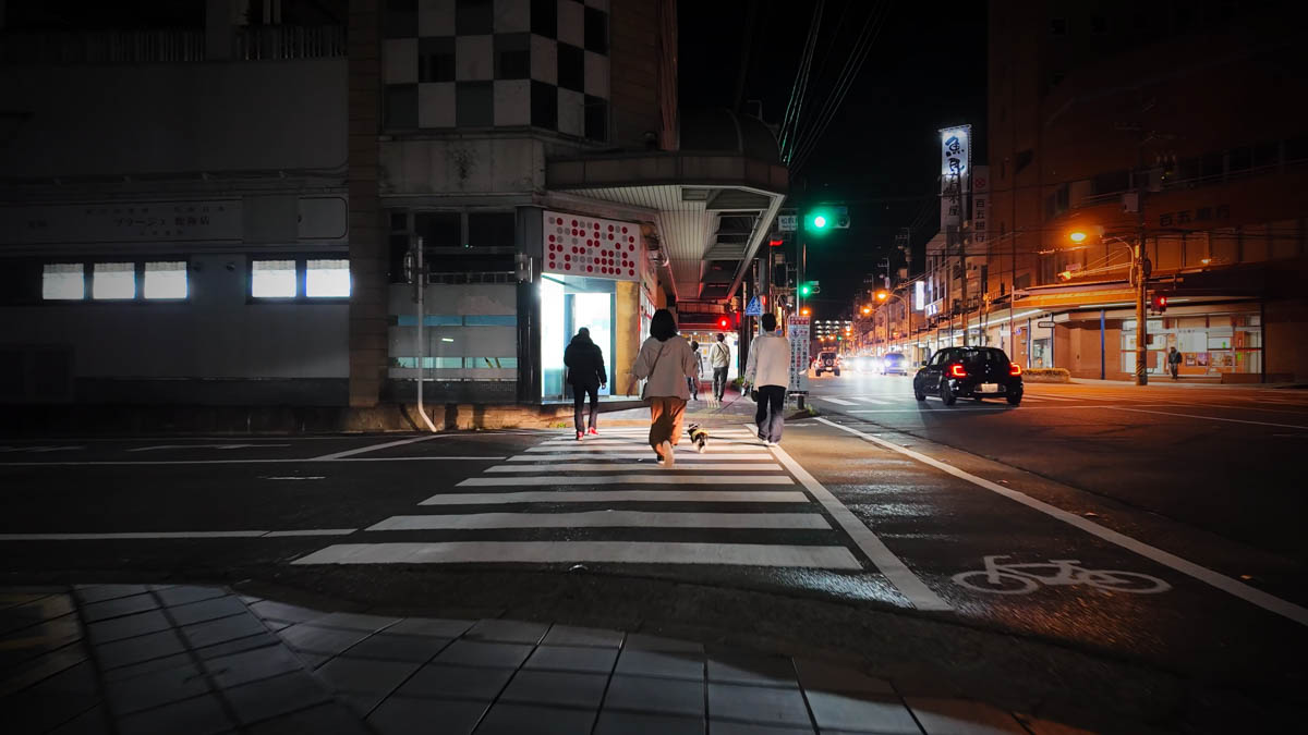 People walking along the covered footpath arcade near Matsusaka Station