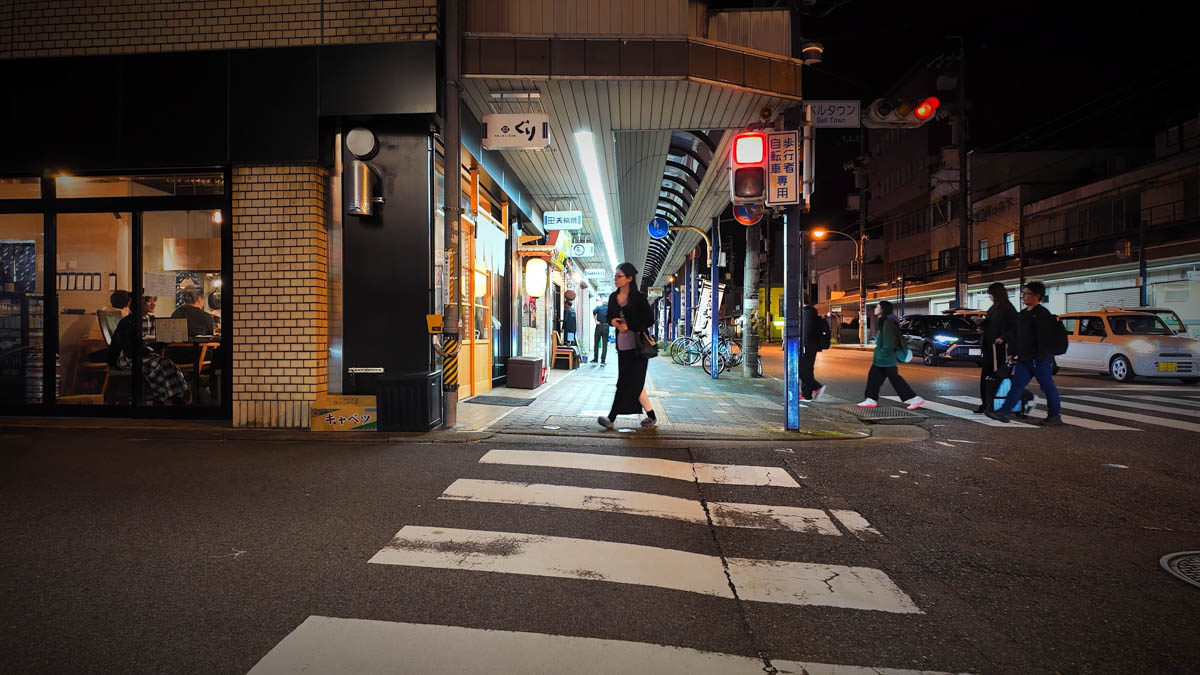 A lively izakaya with a noren curtain, customers visible inside
