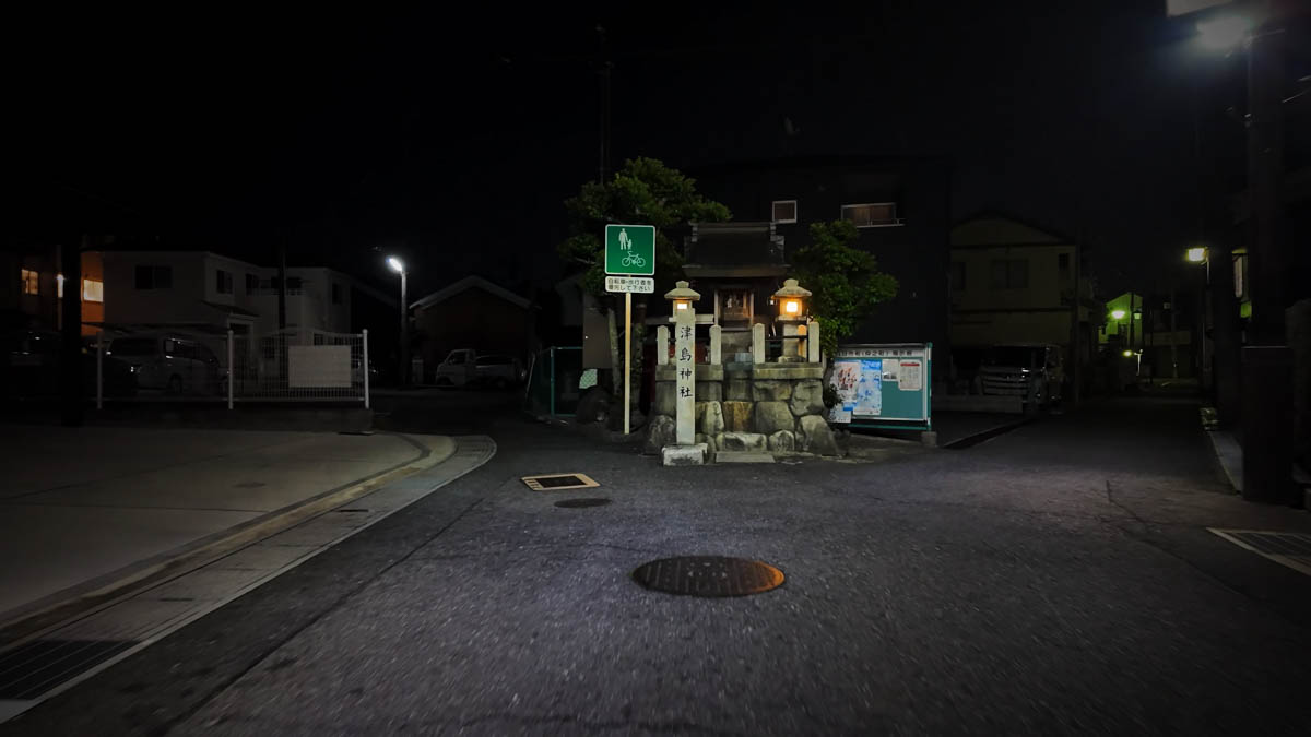 A small roadside shrine tucked away at the edge of the shopping street