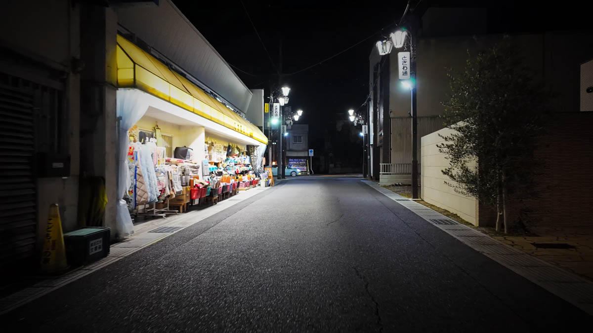 A street lamp sign reading "Tokiwa-dōri" beside a clothing and sundry goods store
