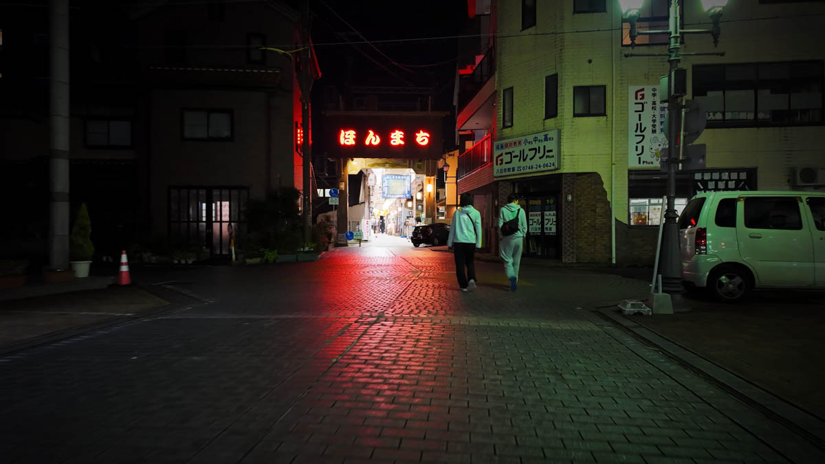 The entrance to Honmachi Shopping Arcade, its red neon sign glowing in the dark