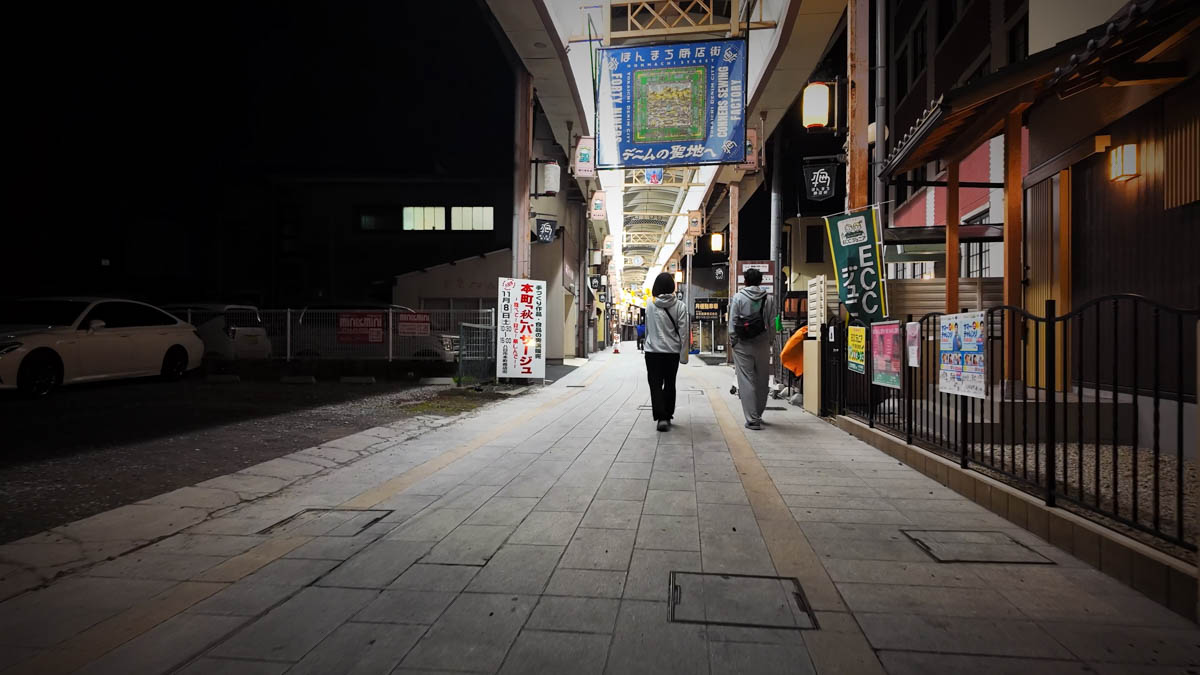 A large banner hanging in the arcade reading "To the Sacred Land of Denim"