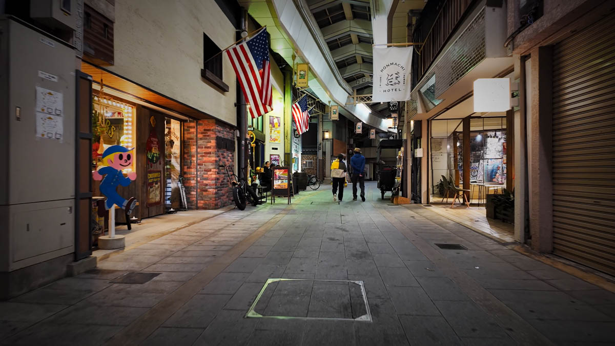 A denim shop on the left and a modern hotel across the street