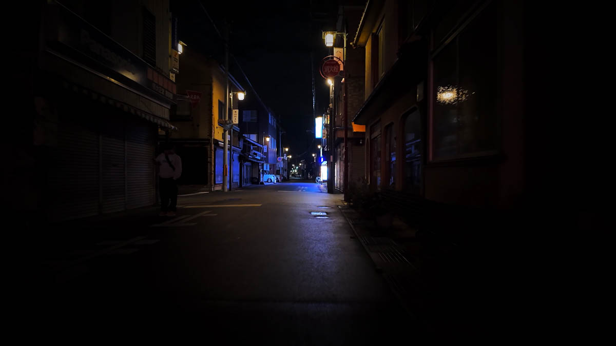 A deep lane of old buildings housing a low-key bar and dining district, former red-light area