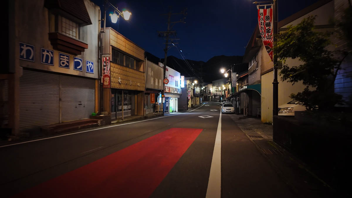 Shopping street at night, streetlamps glowing Back in the shopping street at night, the streetlamps offering a reassuring warmth