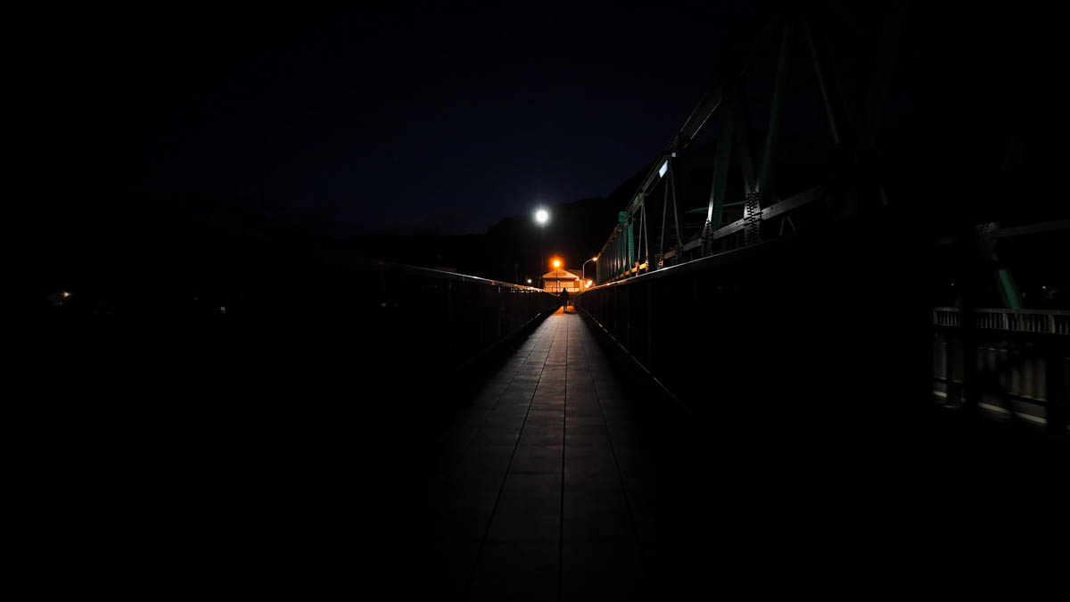 Hida River from the bridge at night The dark surface of the Hida River seen from a bridge at night, a faint glimmer of light from the far bank