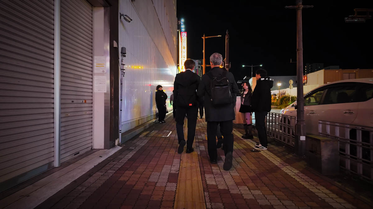 Touts calling out to a group moving from one bar to the next