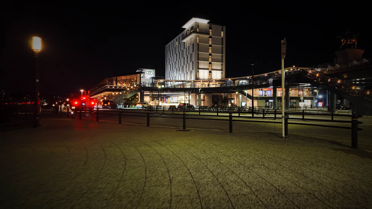 A mixed-use complex with a hotel along the riverside, with a pedestrian deck visible