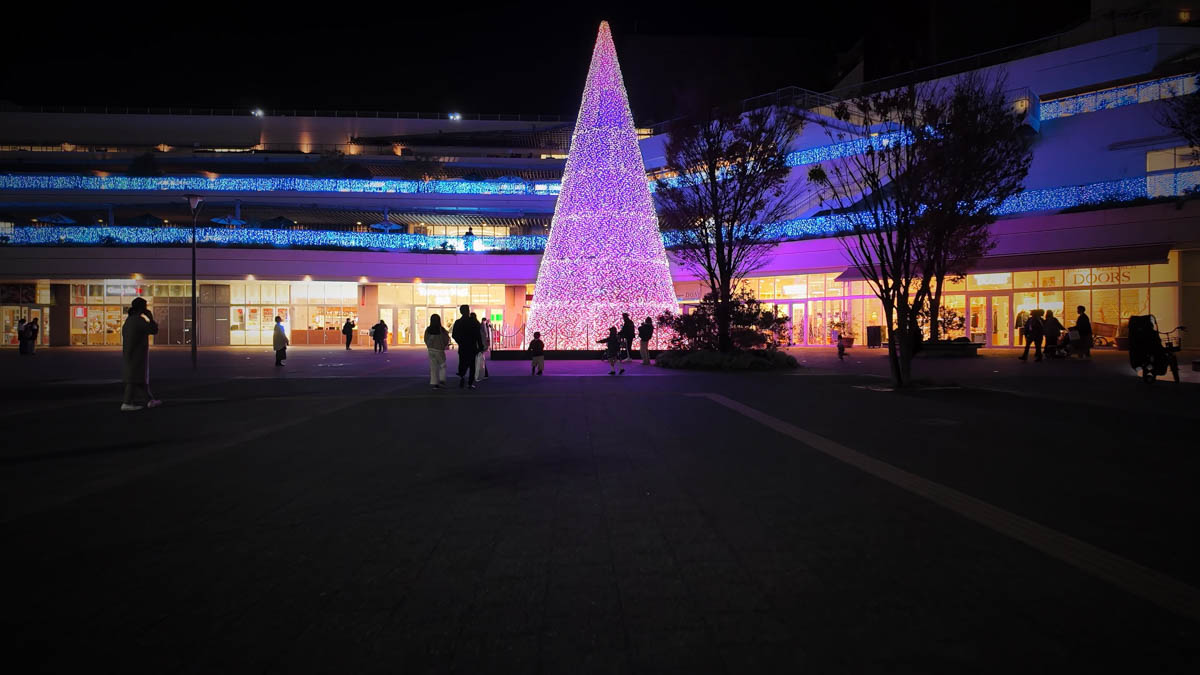 A giant illuminated Christmas tree in front of Terrace Mall Shonan, lighting up the station plaza at night