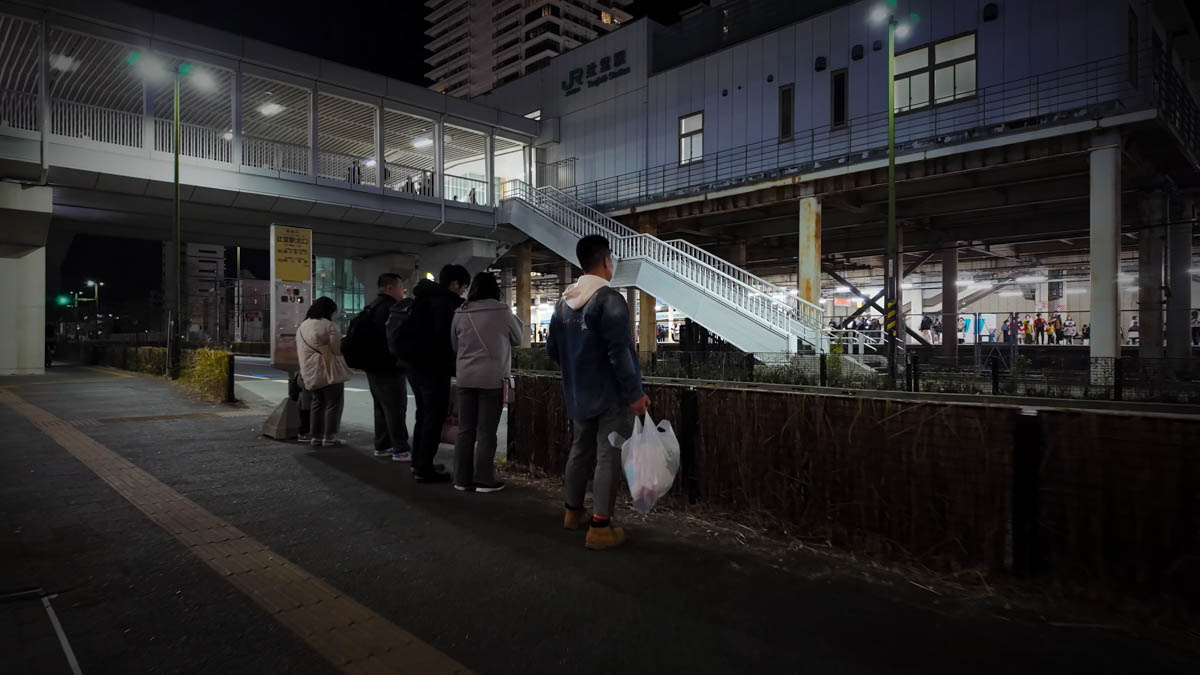 Tsujido Station building and a bus stop with people waiting in line
