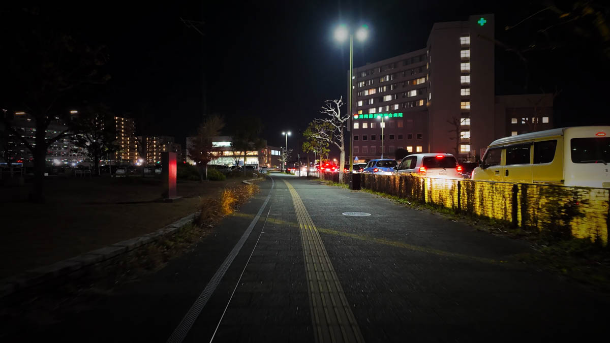 Wide parking area and a large hospital near the station