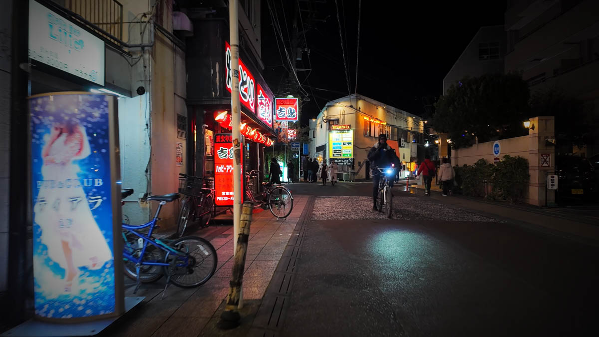 赤く光る焼き鳥屋の看板と薄暗い路地