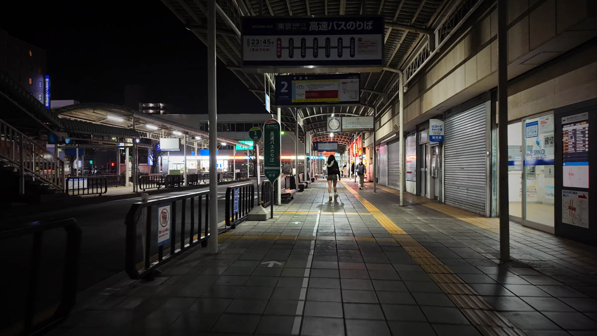 The street in front of Kuwana Station at night. A quiet station plaza lit by street lamps