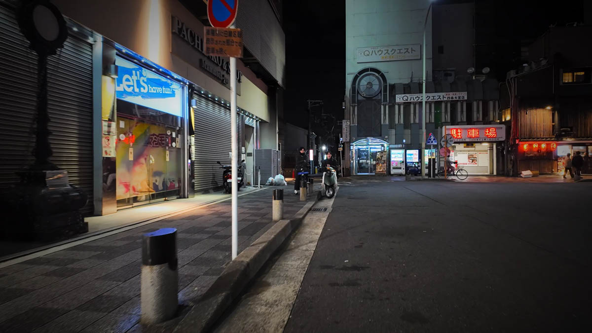 A street near Omiya Station at night, lined with shuttered storefronts and small buildings