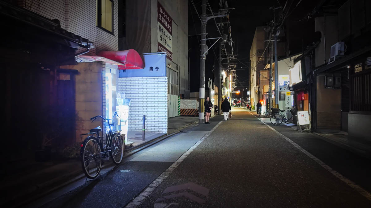 A night alley near Omiya Station, with a lit entrance and a bicycle by the wall
