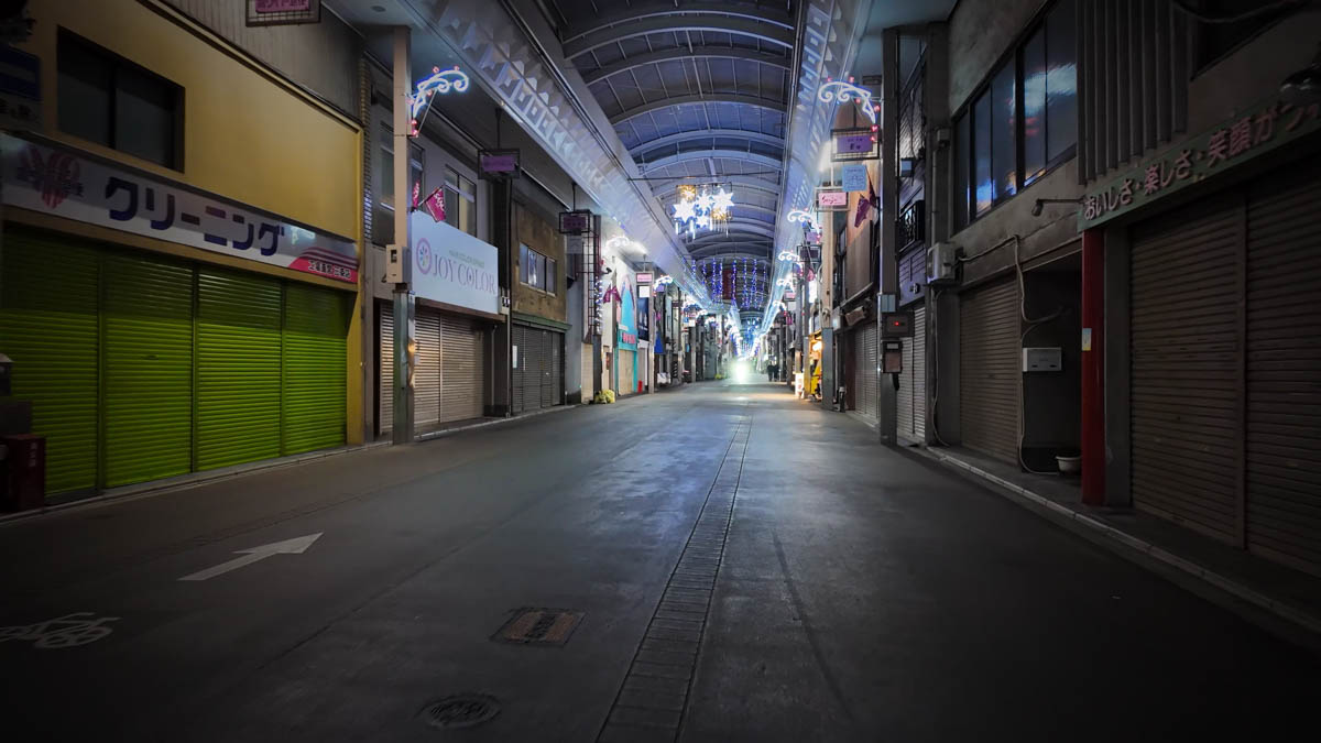 A quiet covered arcade stretching into the distance, with closed shops on both sides