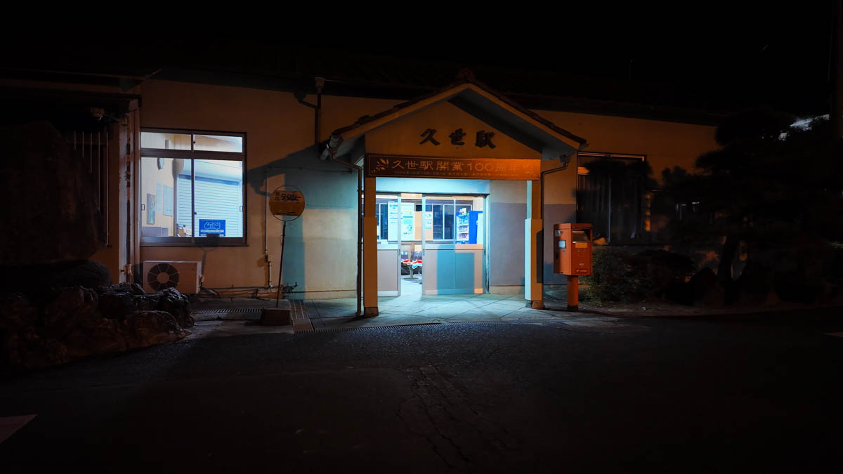 Kuse Station building at night, with a banner marking the station's 100th anniversary