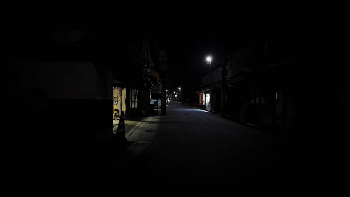 A very quiet night street with only a few small lights visible