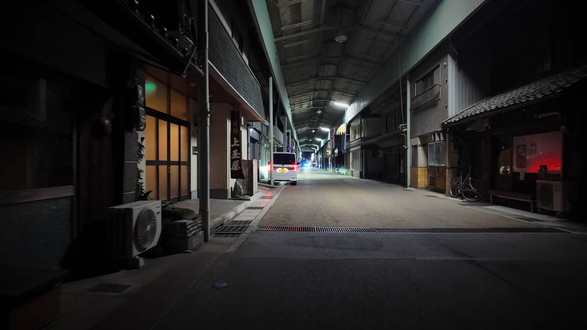 Inside Kamimachi Shopping Street, with a Kamitamaya sign and a car driving deeper into the arcade