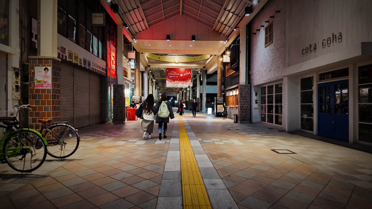 Inside a covered shopping arcade near Kurashiki Station, with Christmas decorations and people walking beneath the roof