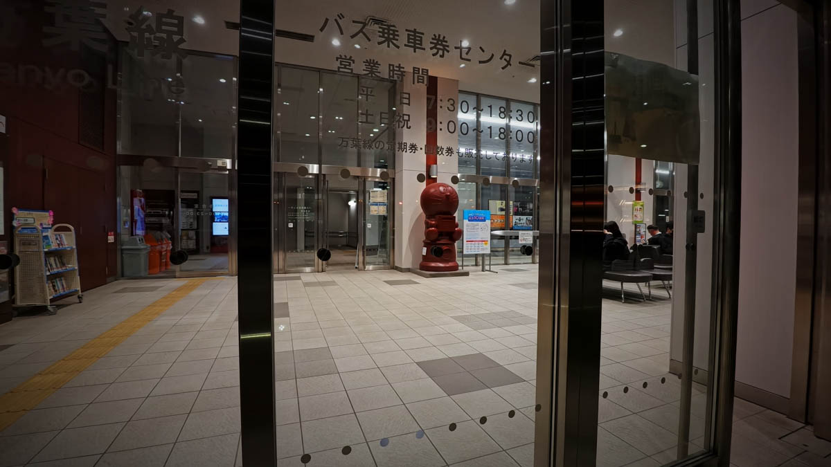 The bus ticket center at Takaoka Station, with a red "Doraemon Post" mailbox placed in the center
