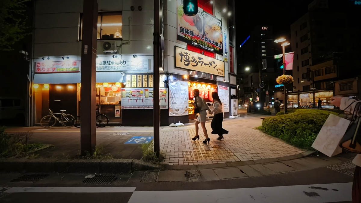 富山駅近くの博多ラーメン店。店の看板と歩道を渡る人が見える