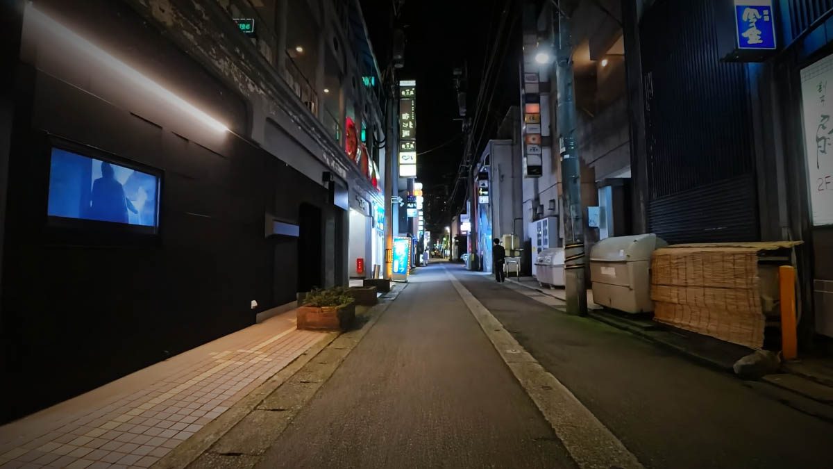 富山駅近くの細い路地。ビルの看板と店舗の明かりが奥へ続く