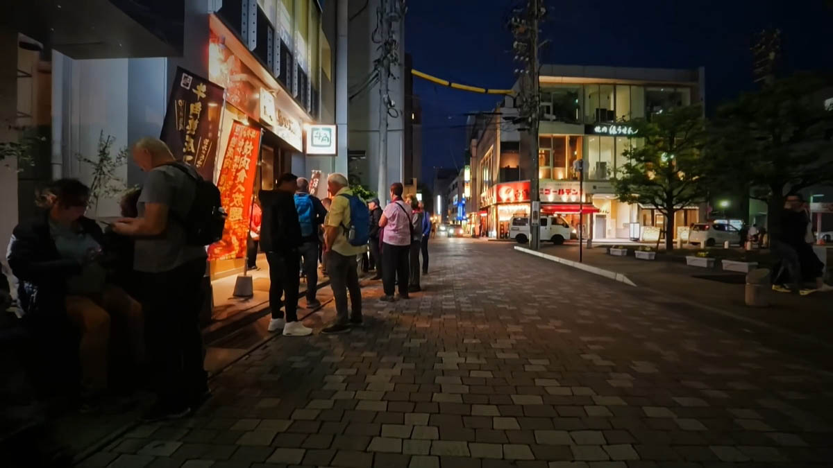 All-you-can-eat banners for Gyukaku, and people gathered in front of Toyoko Inn