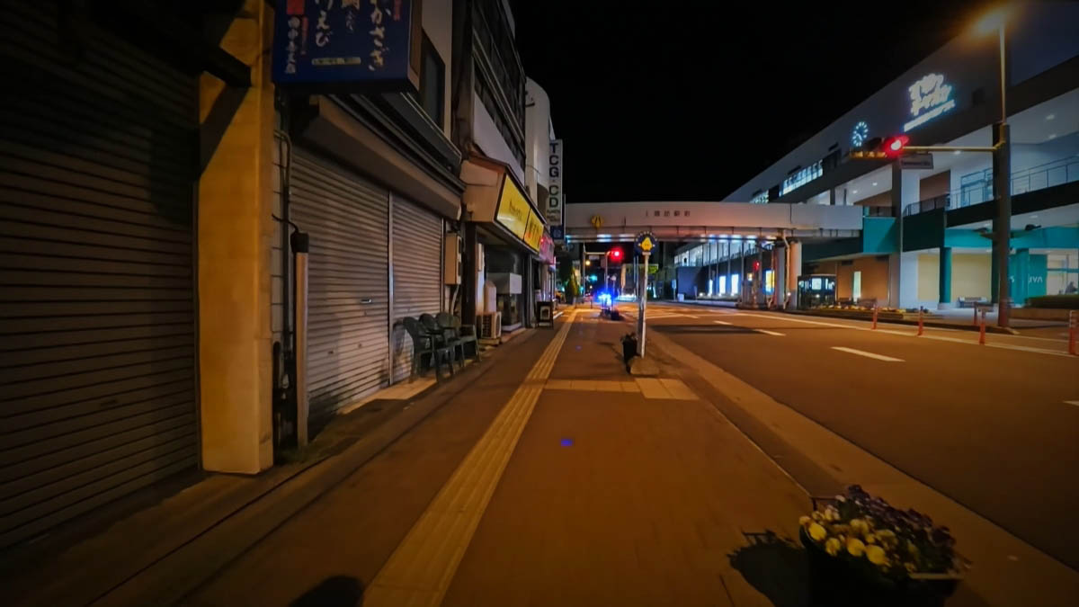 上諏訪駅前の歩道橋 駅前通りと歩道橋。シャッターの店と右側の明るい建物