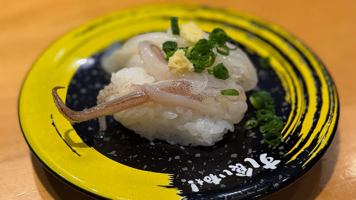 すし食いねぇ! 富山湾産イカゲソ すし食いねぇ!の黄色い皿に乗った富山湾産イカゲソの握り。生姜とねぎがのる