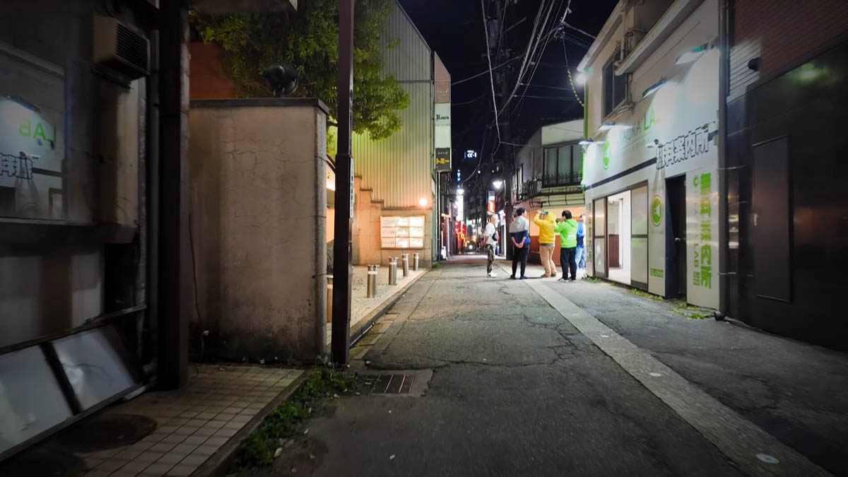 Annaijo LAB Bright Annaijo LAB entrance; a small group talking down the alley
