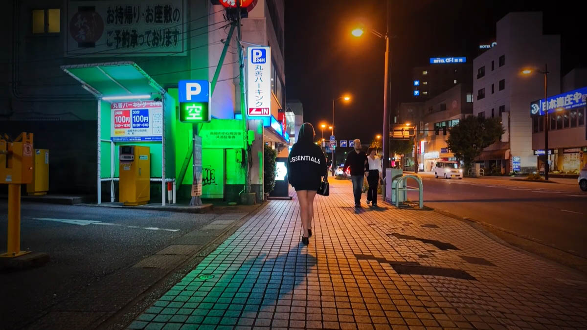 Maruzen Parking Maruzen Parking green "P vacant" sign; Hotel Alpha-1 and Nihonkai Shoya neon in the distance
