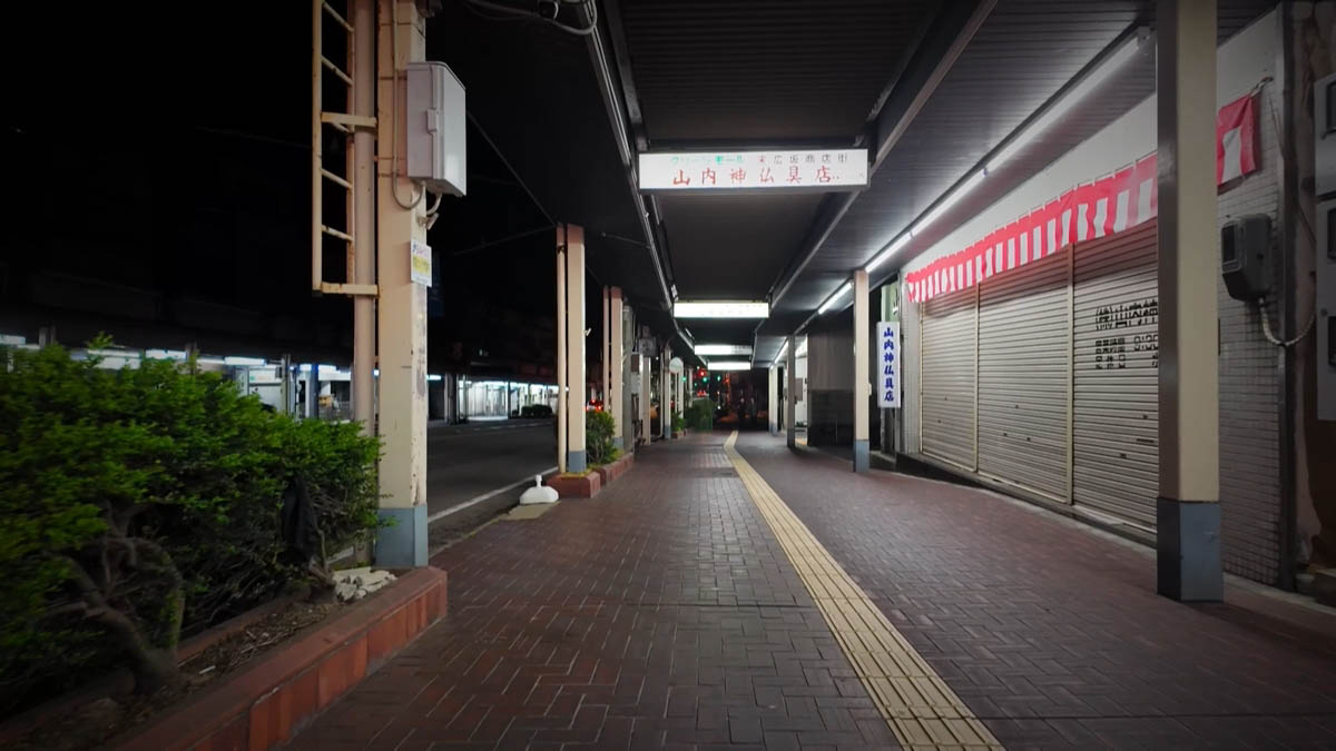 Suehiro-zaka Suehiro-zaka shopping street sign and Yamauchi Buddhist altar shop red neon; brick pavement