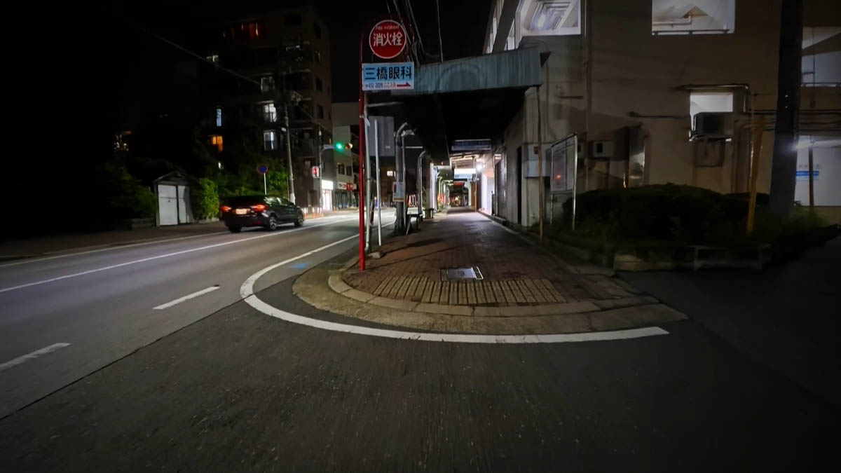 Mitsuhashi Ophthalmology Red fire-hydrant marker and Mitsuhashi Ophthalmology sign; a dark car driving away
