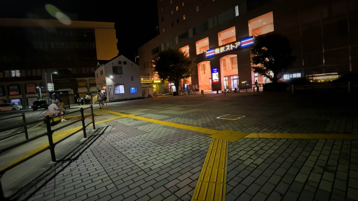 Tobu Store and koban Tobu Store blue sign and koban police box; yellow tactile paving forming a Y on the plaza