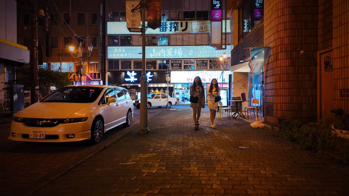 Suehiro Central District banner and two women walking on cobblestones