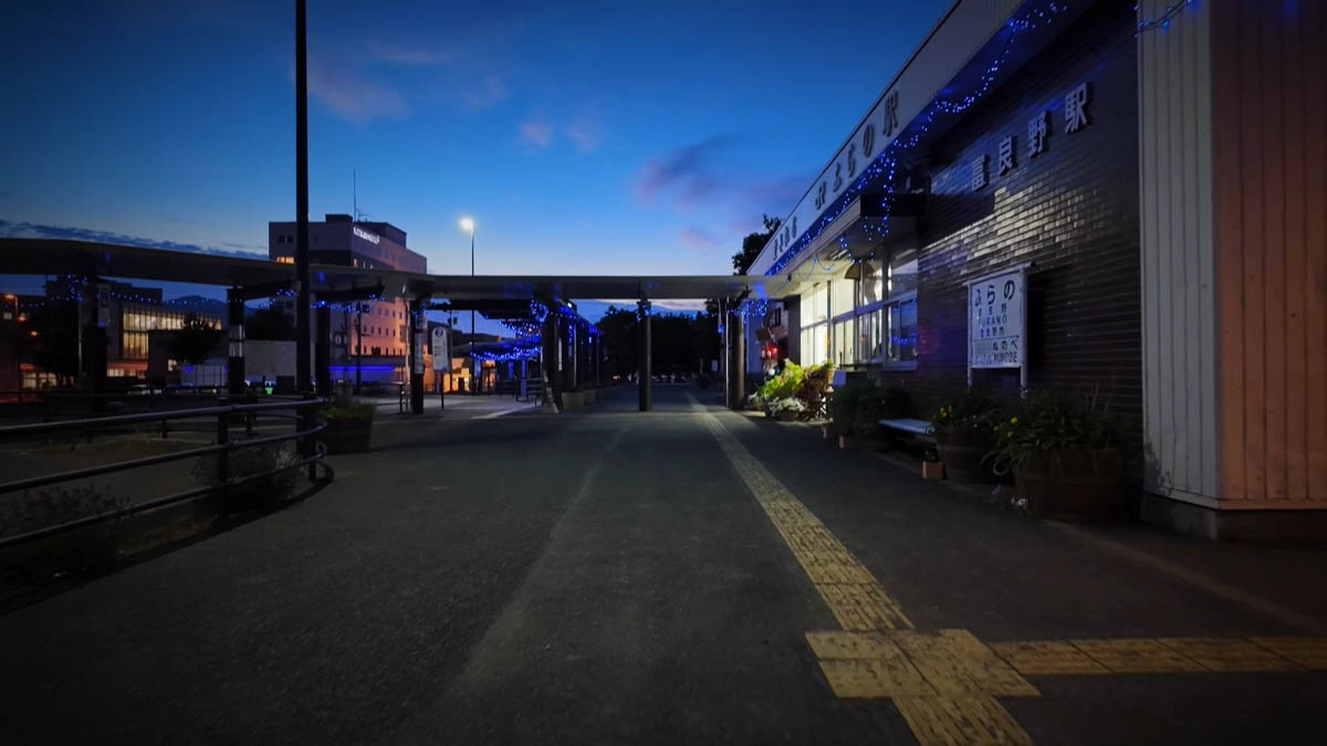 青い電飾と「富良野駅」の文字がある駅舎。夕暮れの空