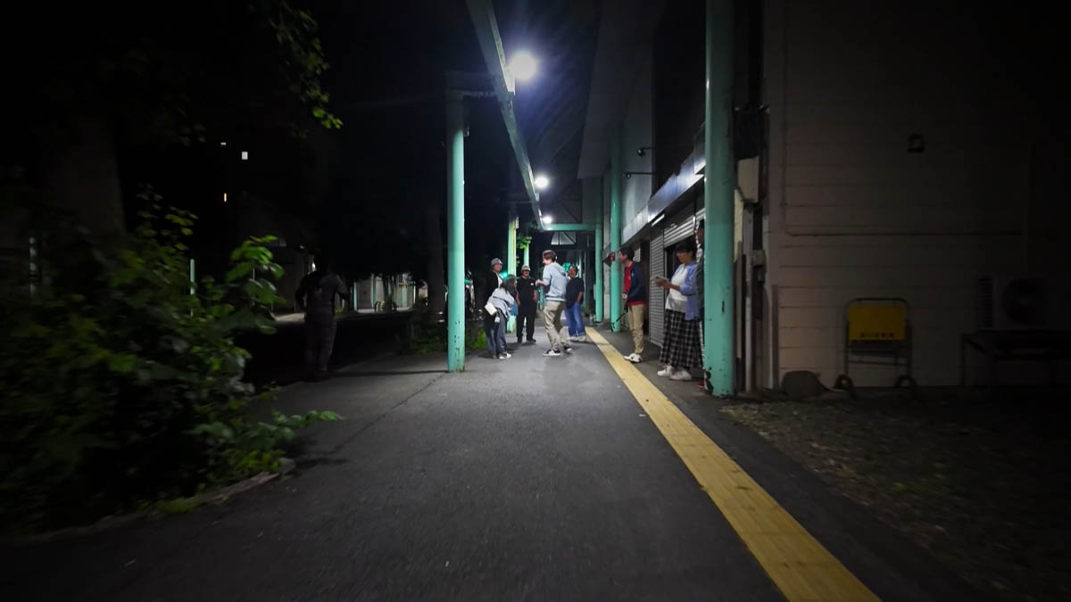 People gathered under the arcade’s green pillars