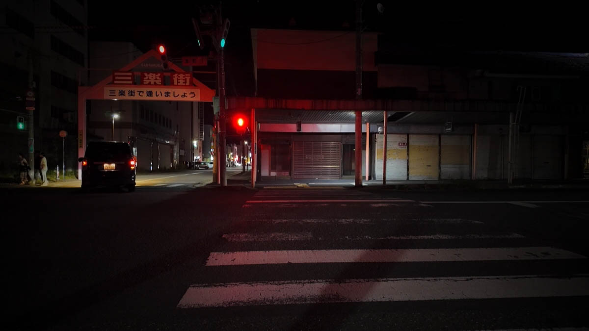 Sanrakugai arch across the road, red traffic light, empty crosswalk