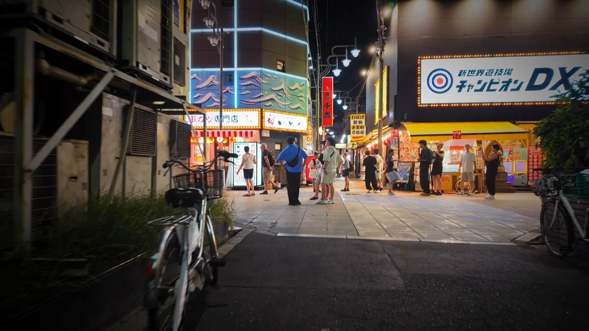 新世界の入口 「新世界遊技場 チャンピオン DX」の看板と串カツ専門店