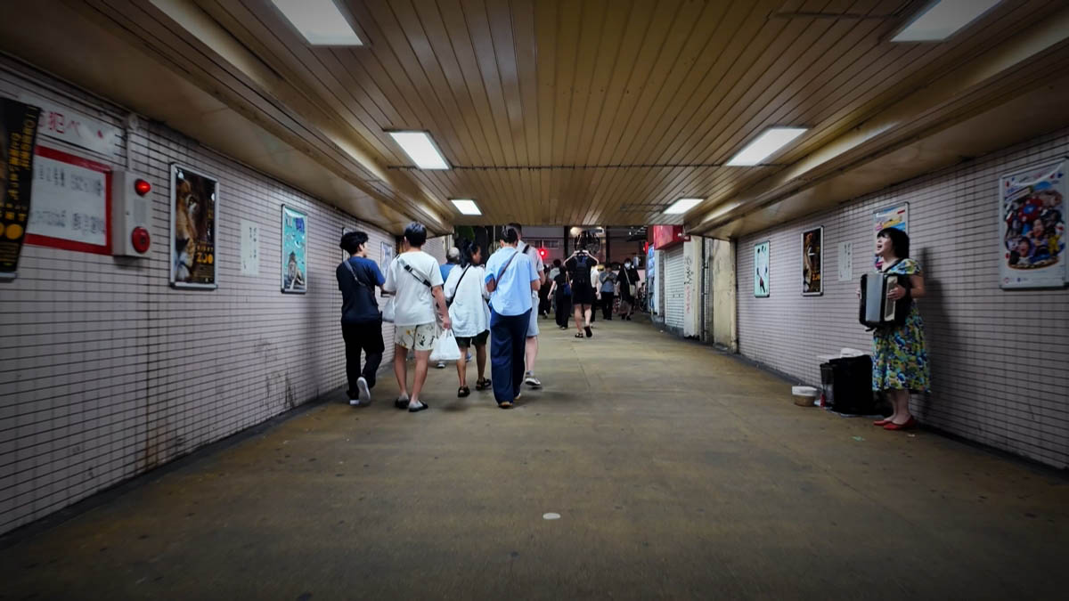 地下通路 地下通路。アコーディオンを弾く人と、出口へ向かう歩行者
