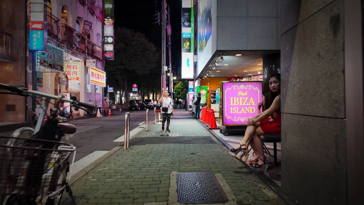 Pub IBIZA ISLANDの看板と、店先の人