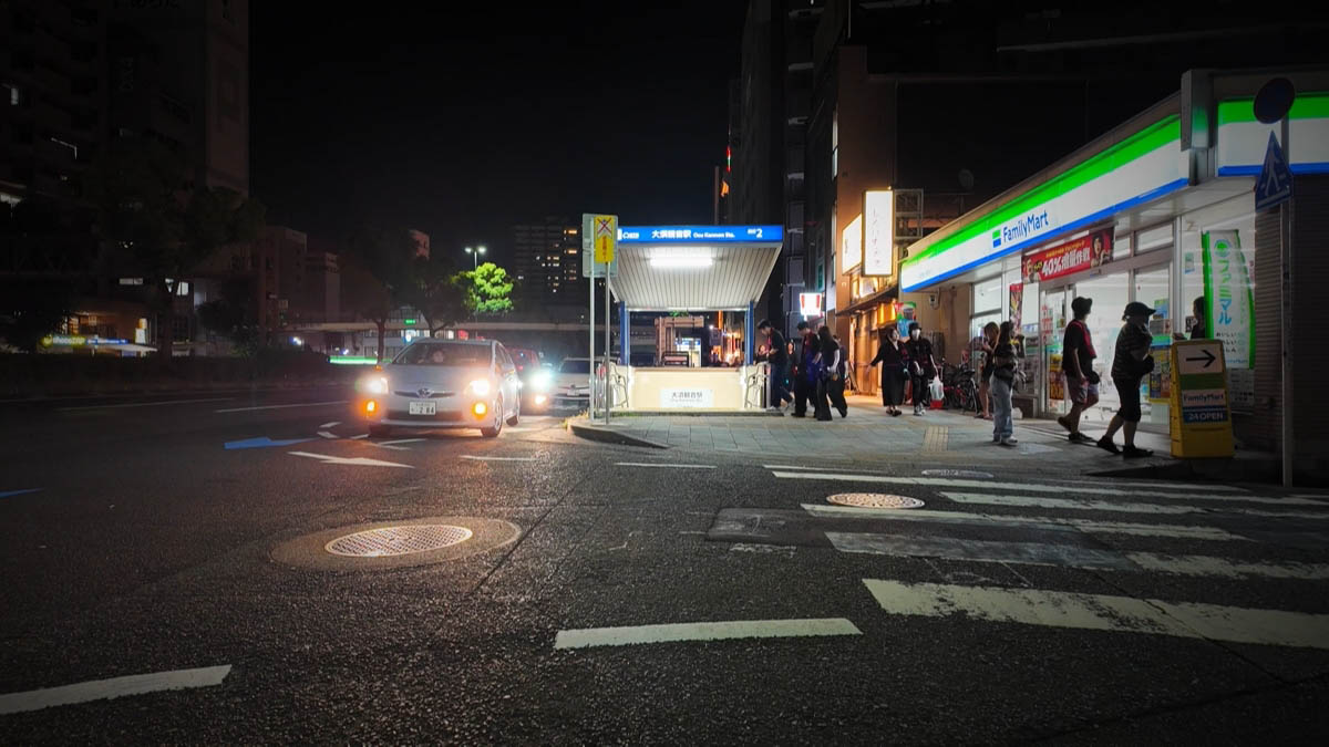駅出口の明かりとファミリーマート前の歩道