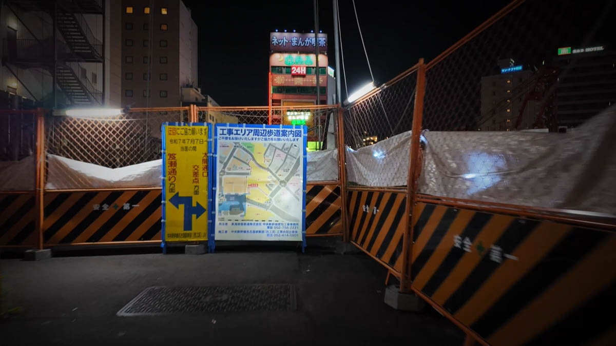 Closed sidewalk Construction fencing and a sign toward the Taiko-dori exit